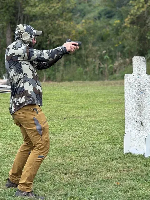 Instructors coaching a student on drawing a handgun from the holster