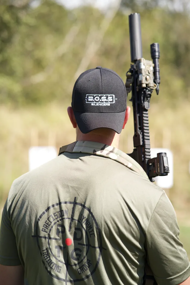 A shooter in Precision Dynamic Training gear working a suppressed rifle